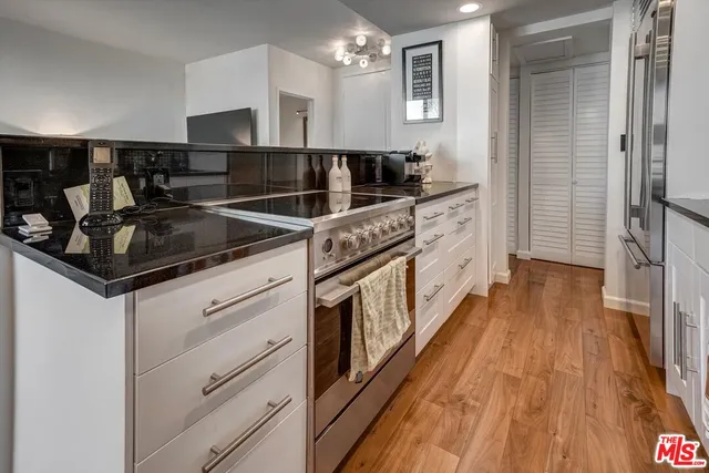 a kitchen with stainless steel appliances granite countertop a sink and wooden cabinets