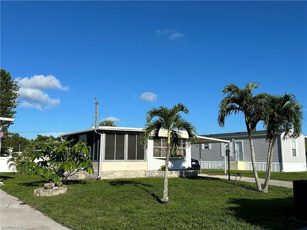 240 Cape Sable Drive Naples, FL 34104 - Photo 2 of 21 a front view of a house with a yard and garage