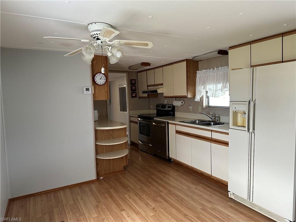 240 Cape Sable Drive Naples, FL 34104 - Photo 10 of 21 a kitchen with stainless steel appliances granite countertop a refrigerator a sink dishwasher a stove and white cabinets with wooden floor
