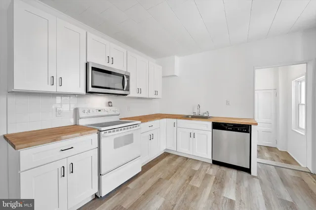 a kitchen with granite countertop white cabinets and white appliances