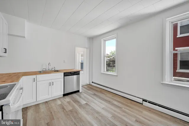 a kitchen with granite countertop white cabinets and white appliances
