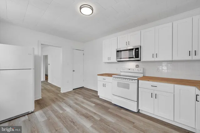 a view of a kitchen with wooden floor and a refrigerator