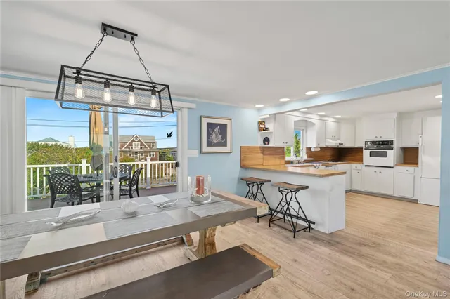a kitchen with stainless steel appliances granite countertop a stove and a view of living room