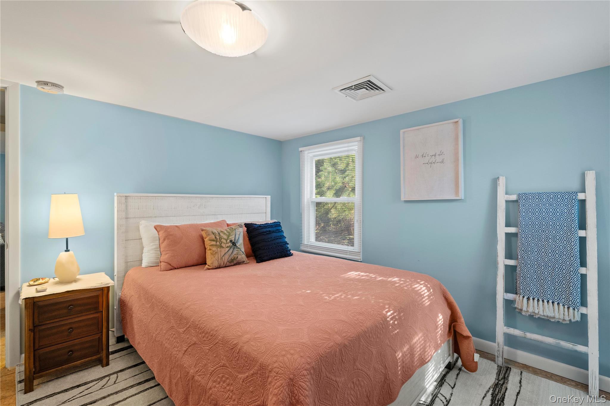 645 Dune Road Westhampton, NY 11978 - Photo 19 of 30 a bedroom with a bed and a lamp