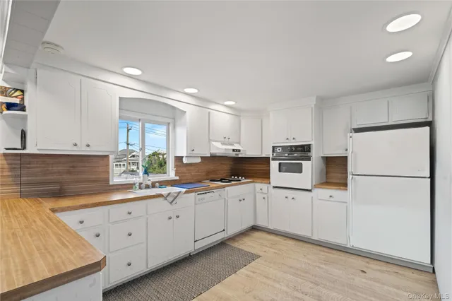 a kitchen with white cabinets sink and white appliances