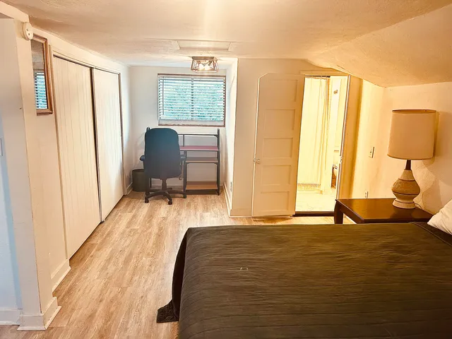 a bedroom with a bed and wooden floor