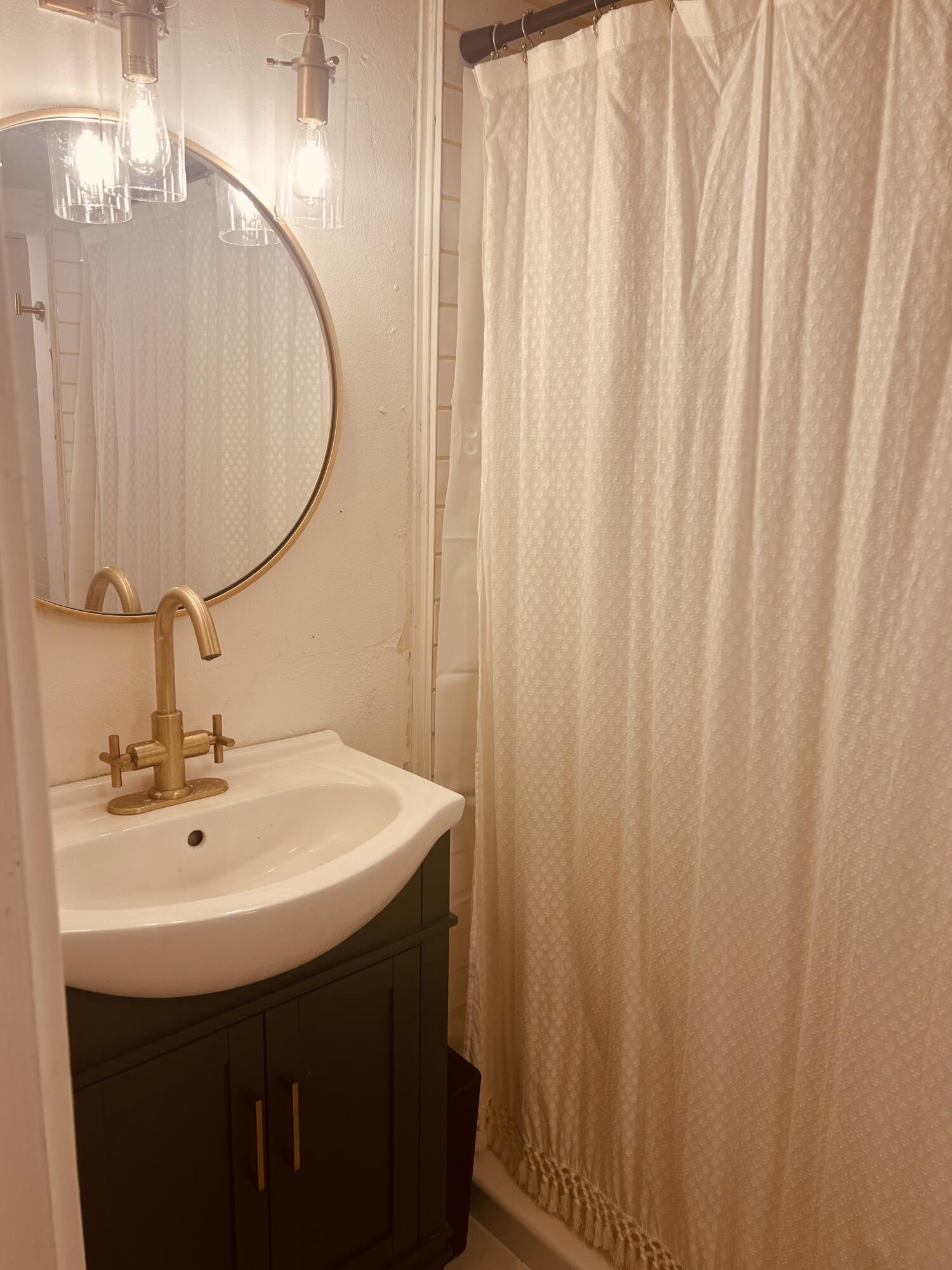 2436 24th Street, Unit BACK Lubbock, TX 79411 - Photo 5 of 6 a bathroom with a sink and a mirror