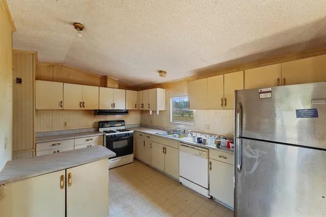 a kitchen with a refrigerator a sink and cabinets