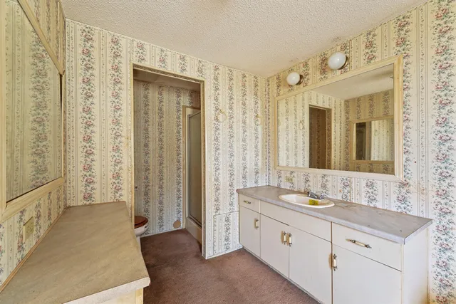 a spacious bathroom with double vanity and a mirror