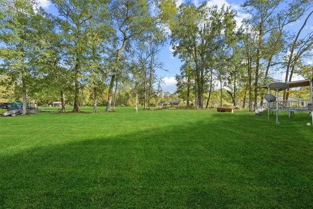 a view of grassy field with benches and trees all around