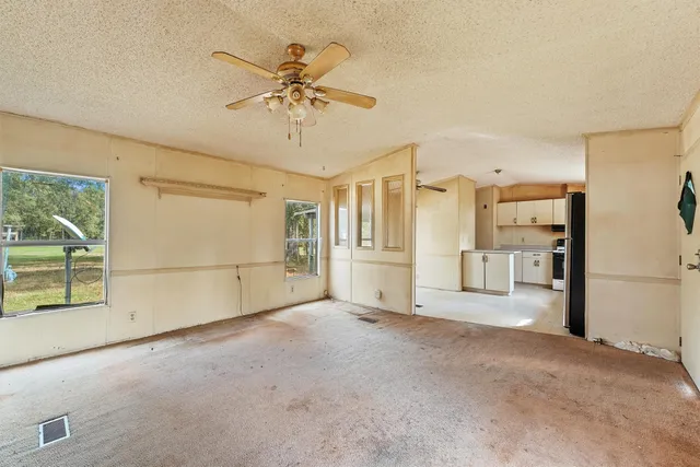 a view of a livingroom with furniture and chandelier fan