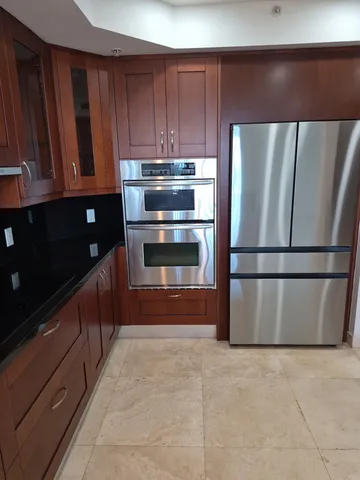 a view of kitchen with wooden cabinet