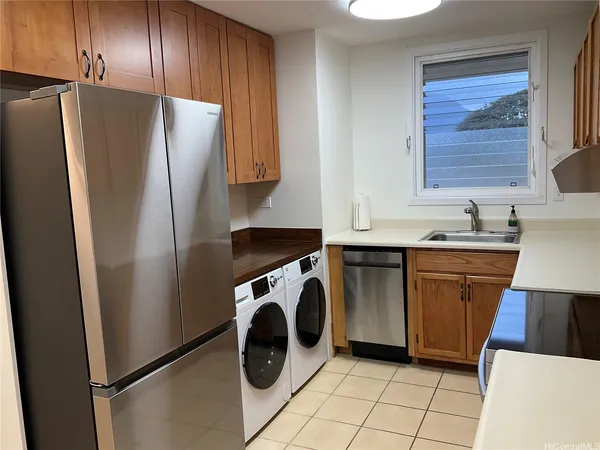 a kitchen with a refrigerator sink and washer dryer