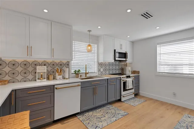 a white refrigerator freezer and a stove sitting inside of kitchen
