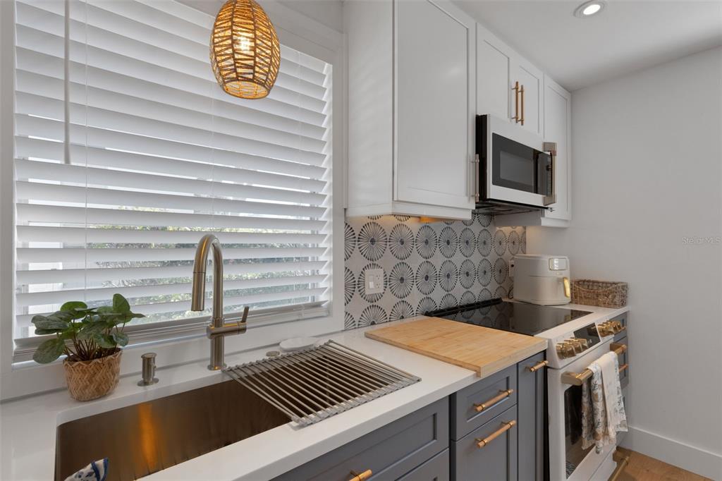 4360 Chatham Drive, Unit 108 Longboat Key, FL 34228 - Photo 16 of 56 a kitchen with a stove and a microwave