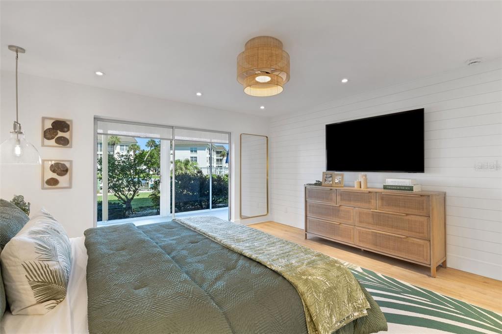 4360 Chatham Drive, Unit 108 Longboat Key, FL 34228 - Photo 28 of 56 a bedroom with a bed and a flat screen tv
