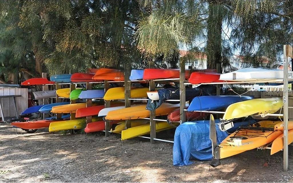 4360 Chatham Drive, Unit 108 Longboat Key, FL 34228 - Photo 47 of 56 a backyard of a house with barbeque oven table and chairs