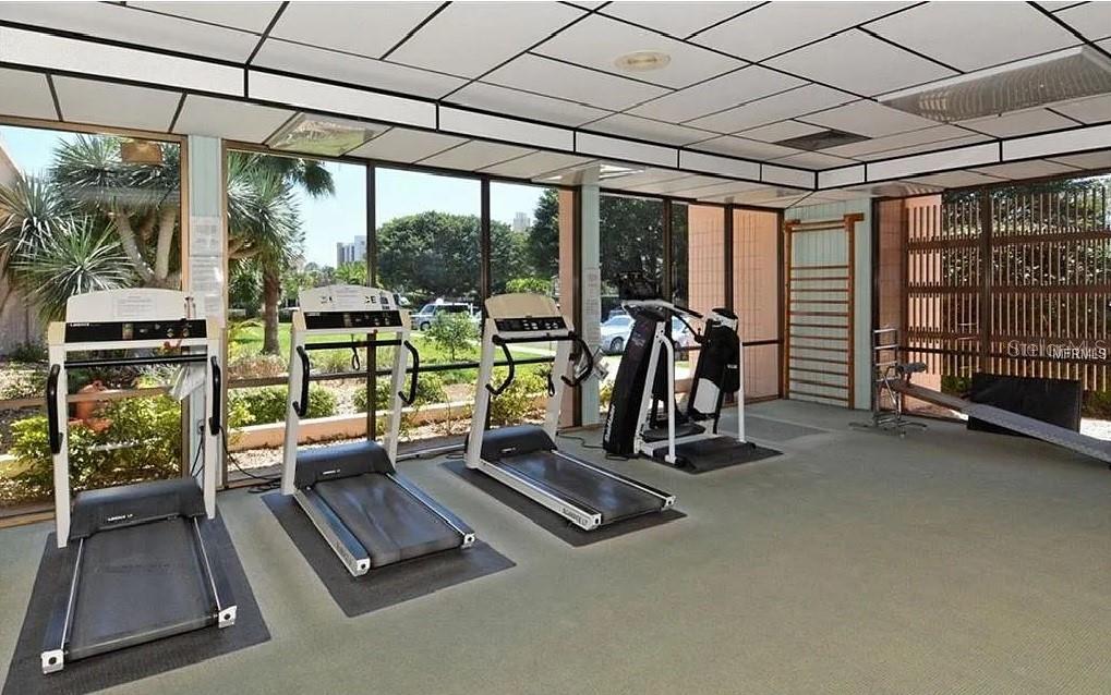 4360 Chatham Drive, Unit 108 Longboat Key, FL 34228 - Photo 55 of 56 a room with gym equipment and large windows