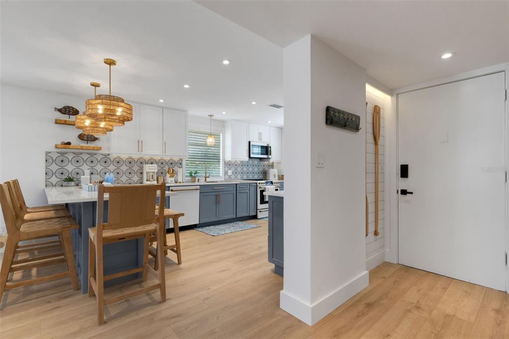 4360 Chatham Drive, Unit 108 Longboat Key, FL 34228 - Photo 6 of 56 a kitchen with a table chairs refrigerator and microwave
