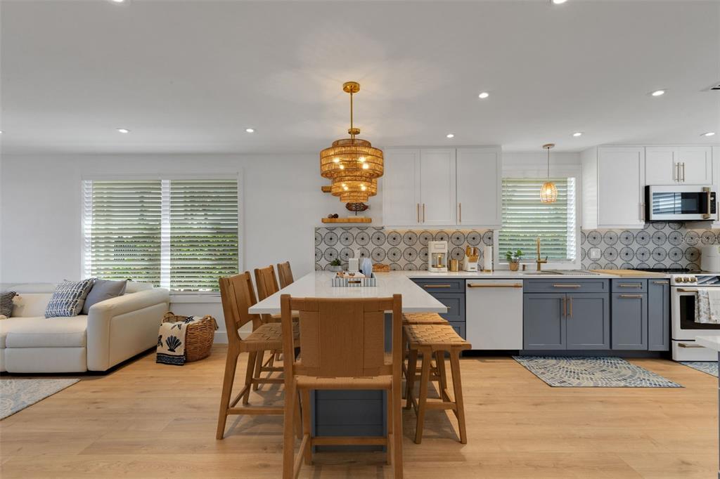 4360 Chatham Drive, Unit 108 Longboat Key, FL 34228 - Photo 7 of 56 a kitchen with kitchen island granite countertop a table and chairs in it