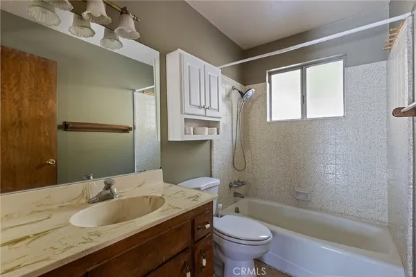 a bathroom with a granite countertop sink a toilet and bathtub