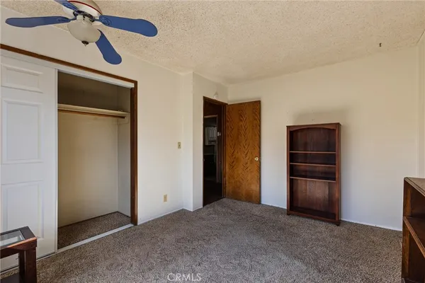 a view of an empty room with closet and cabinet