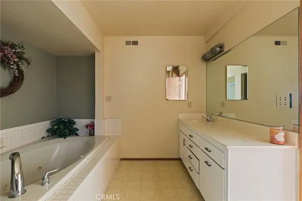 a bathroom with a tub sink and mirror
