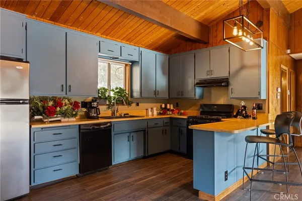 a kitchen with granite countertop a sink cabinets and wooden floor