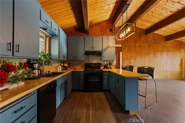 a kitchen with stainless steel appliances granite countertop sink stove and wooden cabinets