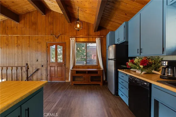a kitchen with refrigerator a stove and a wooden cabinets