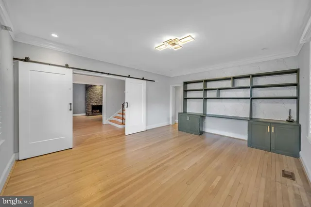 a view of empty room with wooden floor and fireplace