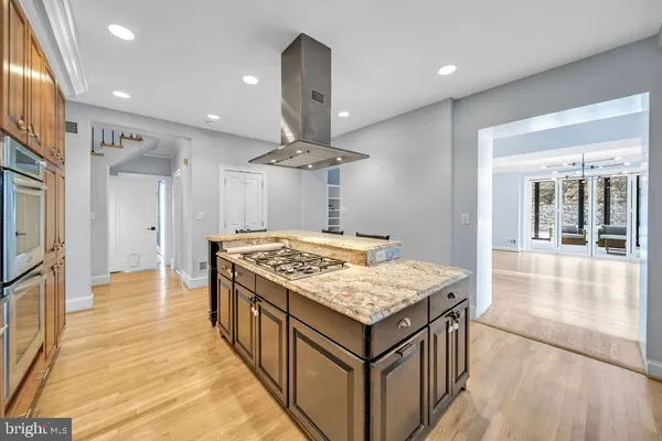 a kitchen with a stove and a wooden floor