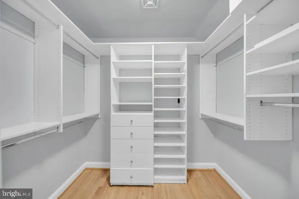 a view of walk in closet with empty racks