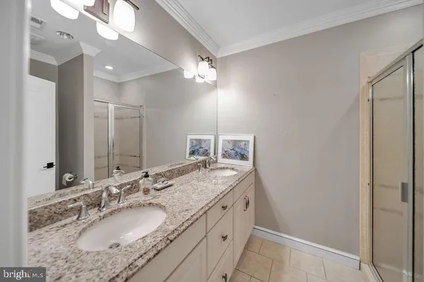 a bathroom with a granite countertop sink a light fixture and a mirror