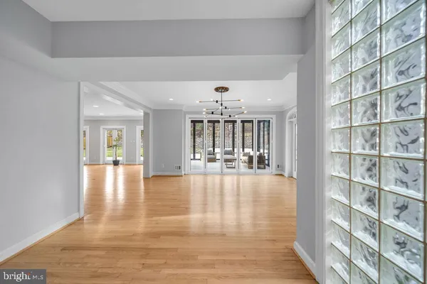 a view of an empty room with kitchen and window