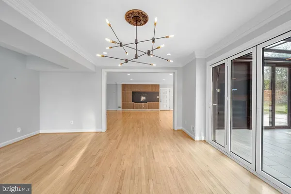 a view of a room with wooden floor a ceiling fan and window