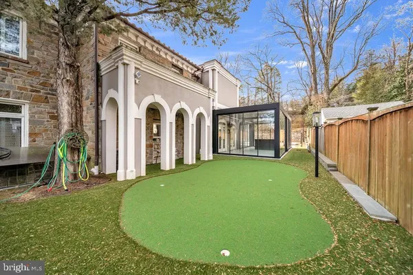 a view of a white house with a big yard and large tree