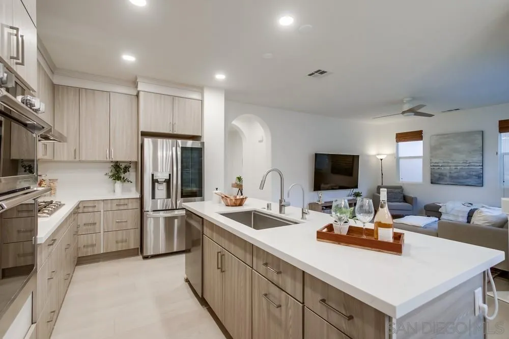 13477 Sydney Rae Place San Diego, CA 92129 - Photo 12 of 73 a kitchen with stainless steel appliances kitchen island granite countertop a refrigerator and a sink
