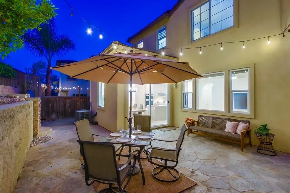 13477 Sydney Rae Place San Diego, CA 92129 - Photo 44 of 73 a view of a patio with a dining table and chairs under an umbrella