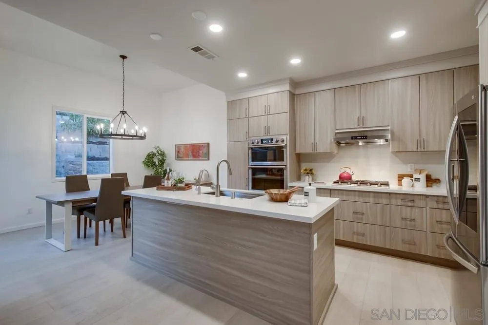 13477 Sydney Rae Place San Diego, CA 92129 - Photo 8 of 73 a kitchen with kitchen island granite countertop appliances cabinets and chairs
