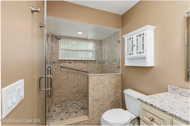 a bathroom with a granite countertop toilet sink and shower