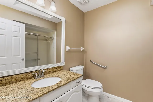 a bathroom with a granite countertop sink a toilet and a mirror
