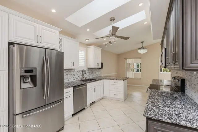 a kitchen with stainless steel appliances granite countertop a refrigerator and a sink