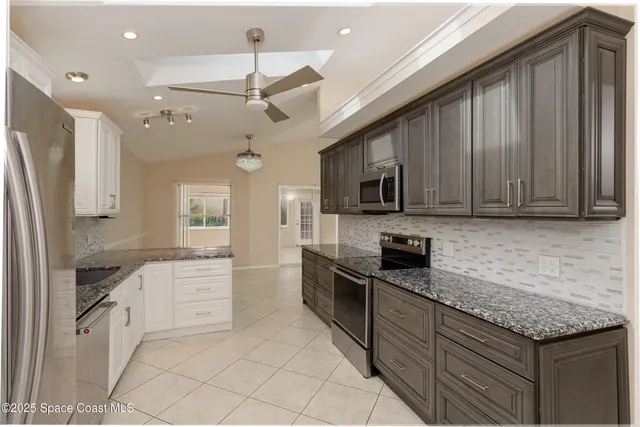 a kitchen with stainless steel appliances granite countertop a stove sink microwave and cabinets