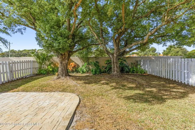 a view of a yard with wooden fence