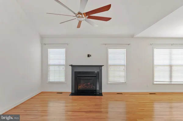 an empty room with windows and fireplace
