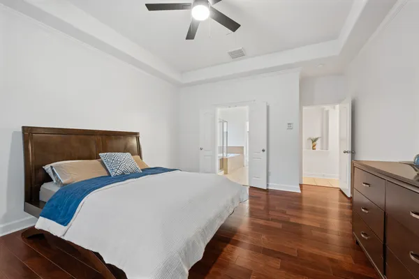 a bedroom with a bed and wooden floor