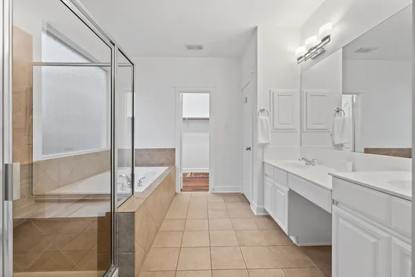 a bathroom with a double vanity sink a toilet and a shower