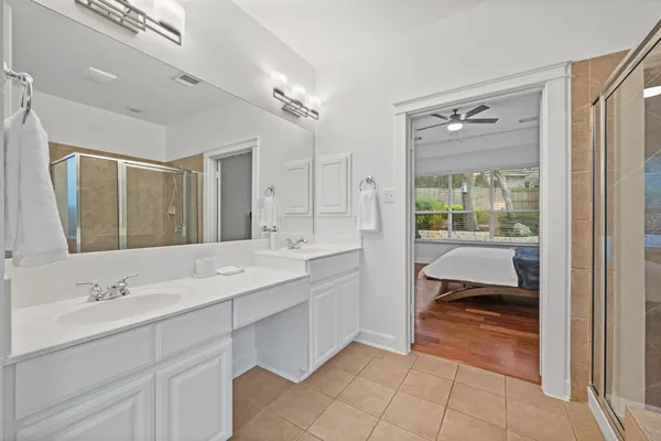 a en suite bathroom with a double vanity sink a mirror and a bathtub