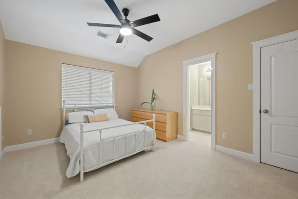 a bedroom with a bed and a ceiling fan